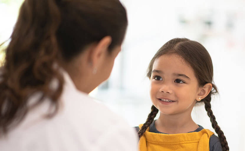 young girl listening to her dentist speak