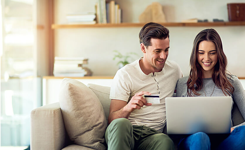 young couple paying a bill online together
