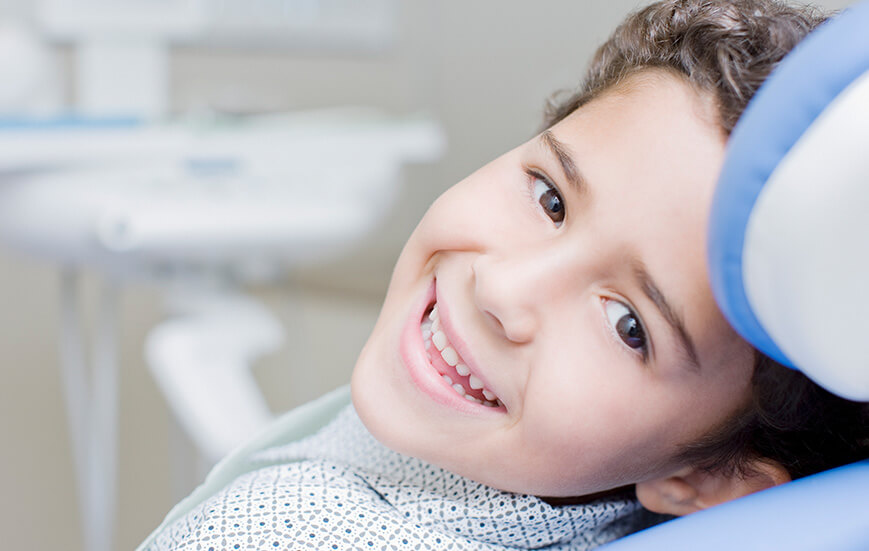 young, smiling boy sitting in a dental chair