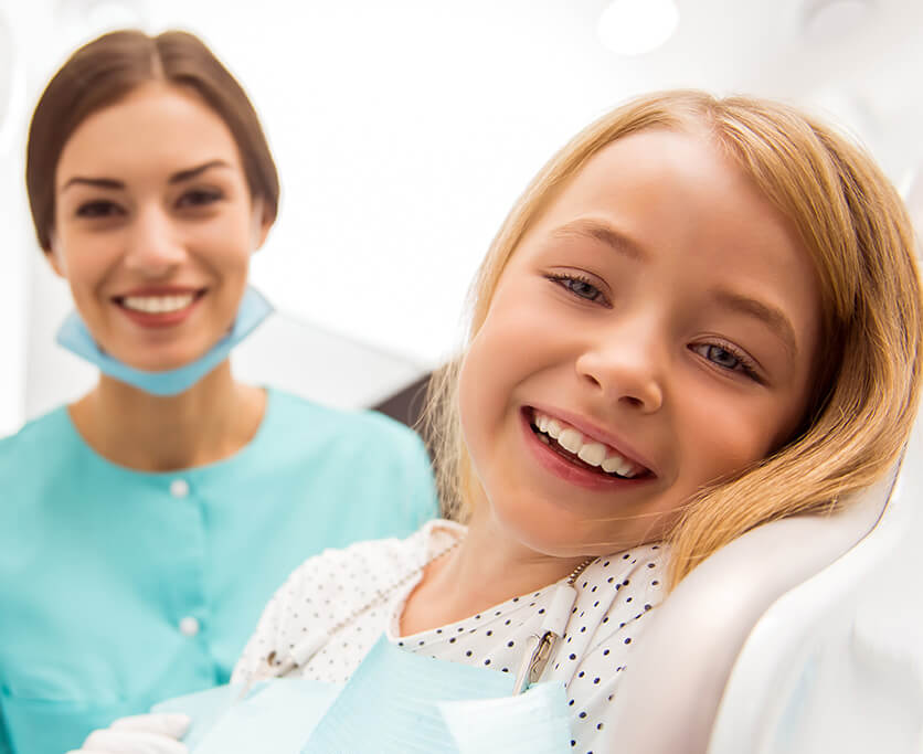 young, smiling girl posing with her hygienist