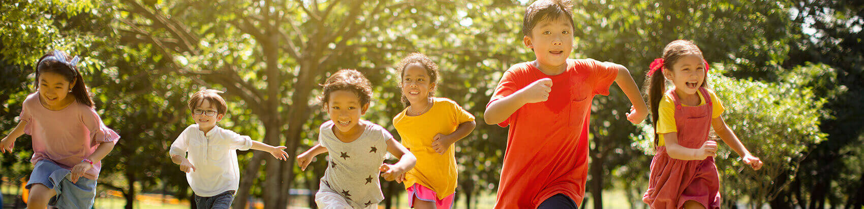 group of happy, smiling children running outside together