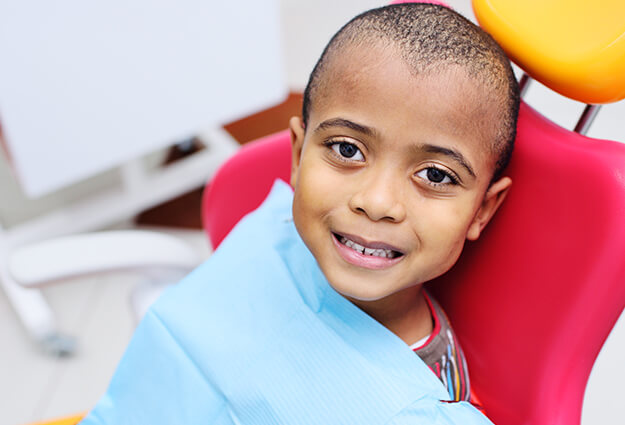 smiling boy sitting in a dental chair