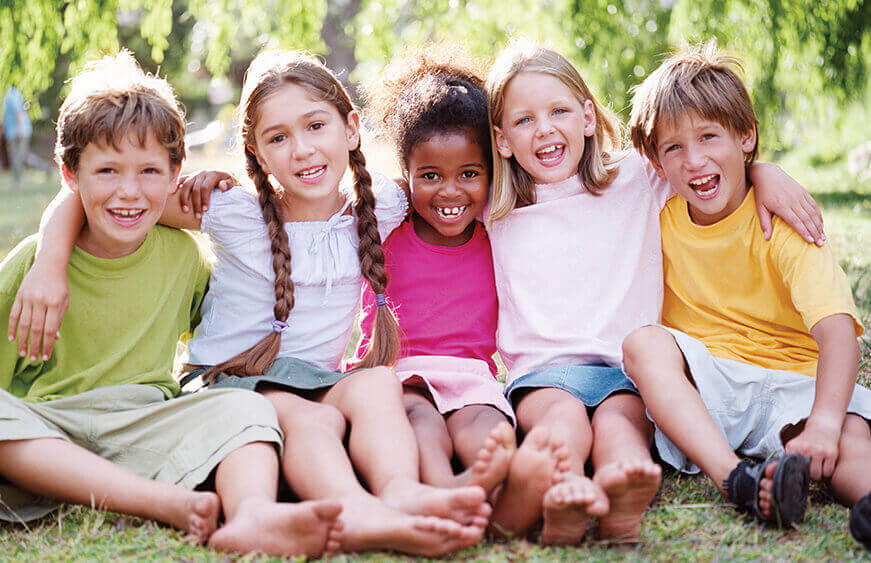 group of happy, smiling children playing outside together