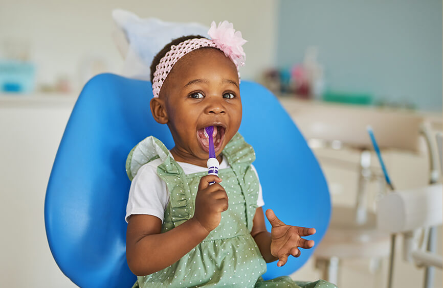 little girl learning how to brush her teeth