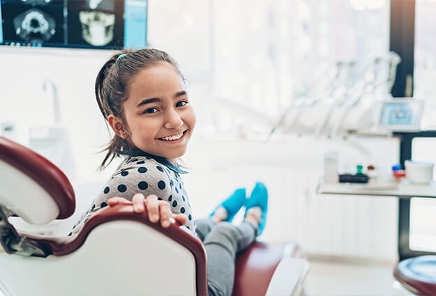 young smiling girl sitting in a dental chair
