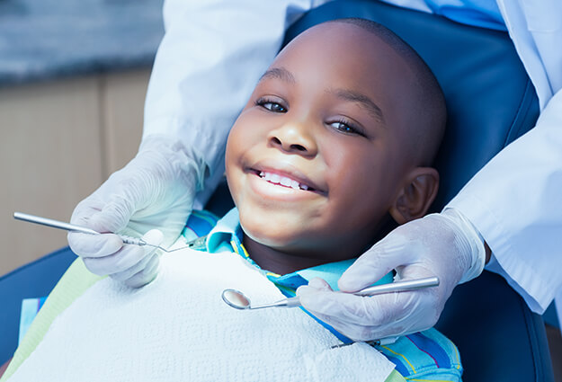 young boy having his teeth examined