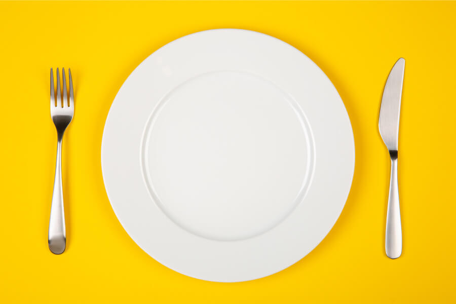 Aerial view of a white plate against a yellow background to symbolize a child's nutrition