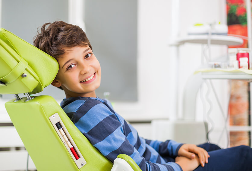 smiling boy sitting in a dental chair